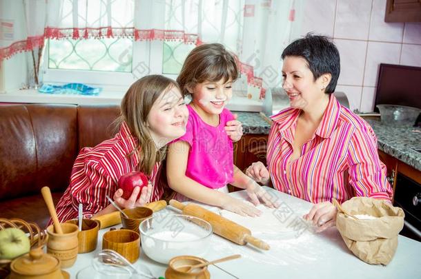 妈妈教学她两个女儿烹饪术向指已提到的人厨房.