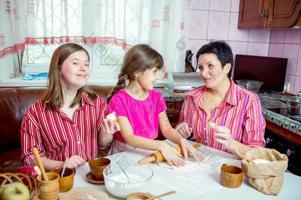 妈妈教学她两个女儿烹饪术向指已提到的人厨房.