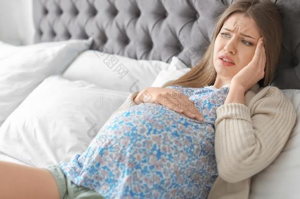 年幼的怀孕的女人受苦从头痛