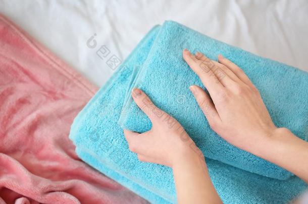 女人可折叠的干净的毛巾向床