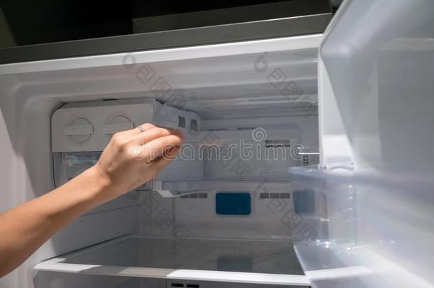 女人手敞开的清楚的塑料制品冰容器采用冰箱.