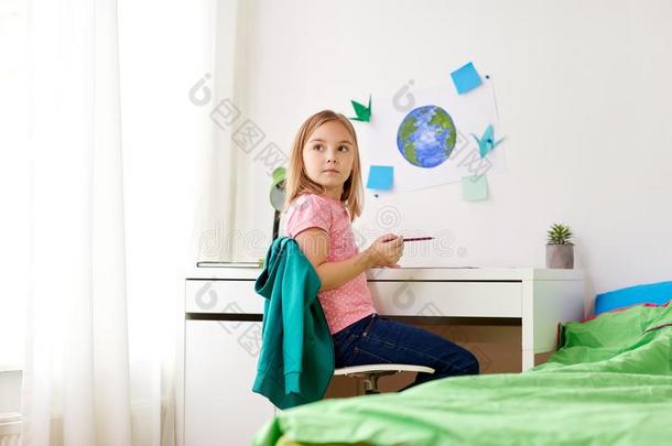 小的女孩做家庭作业或绘画在家