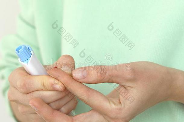 女孩糖尿病的刺手指向测量血