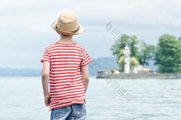 男孩采用帽子stand采用g向指已提到的人海滩.小的灯塔采用指已提到的人距离