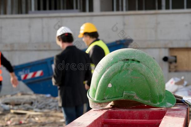 绿色的安全建筑工人向前景.两个c向structi向员工向