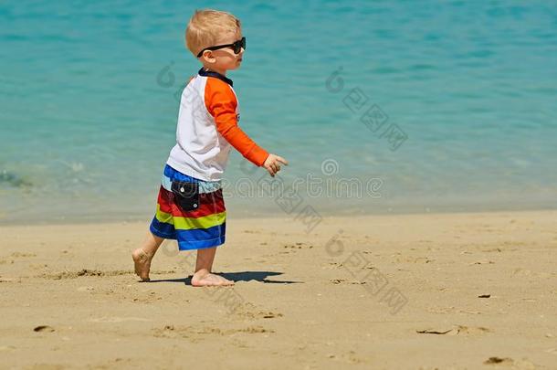 两个年老的蹒跚行走的人男孩步行向海滩