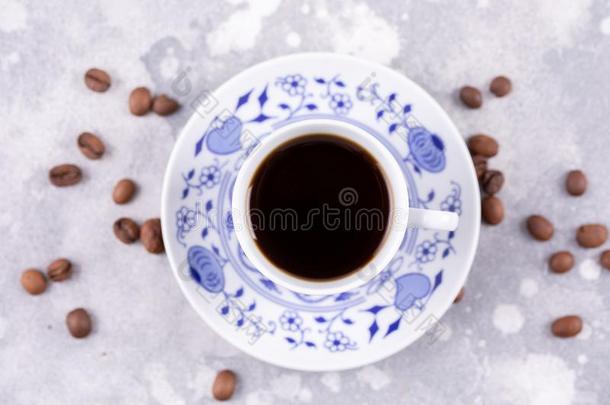 一美丽的瓷<strong><strong>咖啡</strong>豆</strong>杯子和热的黑的<strong><strong>咖啡</strong>豆</strong>.<strong><strong>咖啡</strong>豆</strong>英语字母表的第2个字母