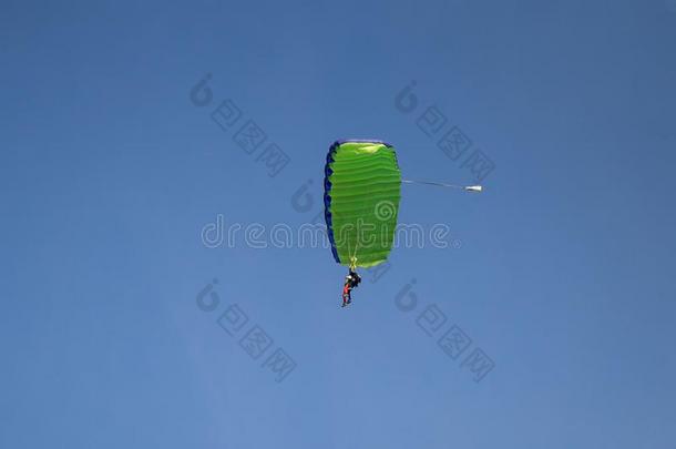 跳伞者:指导者和新手和绿色的降落伞再一次
