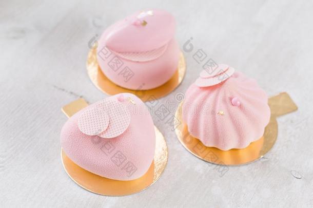 num.三彩色粉笔粉红色的蛋糕向白色的木制的表.小的餐后甜食重量的单位