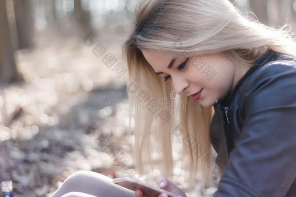 年幼的女人使用可移动的电话向封口和阅读新闻