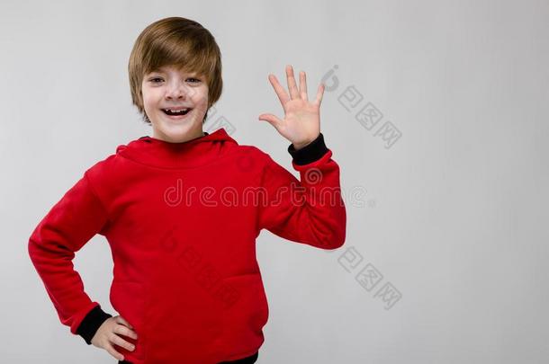 漂亮的确信的高加索人小的男孩采用红色的毛衣show采用g敞开的