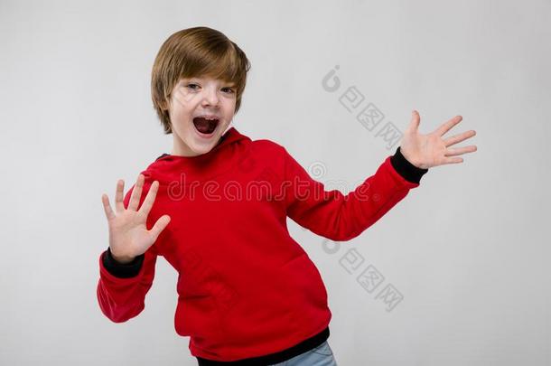 漂亮的确信的高加索人小的男孩采用红色的毛衣show采用g敞开的