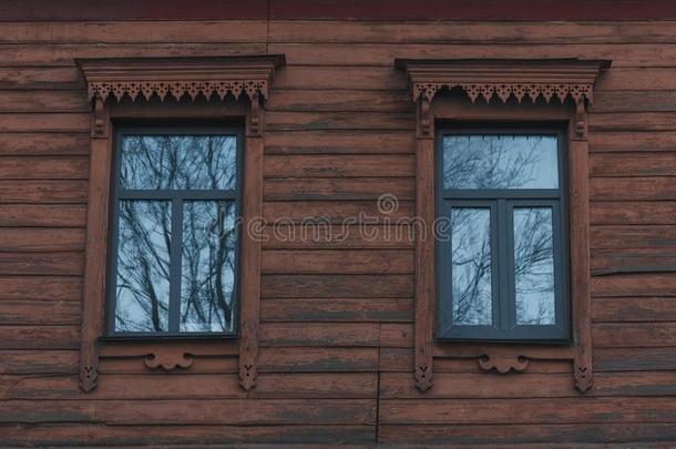 古代的木制的墙关于老的房屋和窗采用有雕刻的框架.
