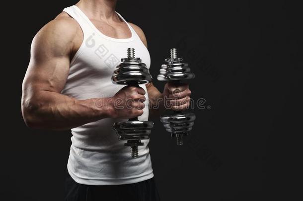 强的运动员的男人和哑铃展示会肌肉的身体