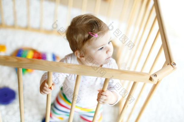美丽的小的婴儿女孩起立里面的<strong>护栏</strong>.漂亮的阿多拉布