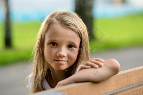 小的女孩和长的头发一次向长凳采用夏公园