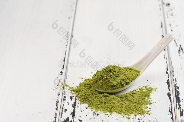 绿色的茶水比赛粉采用一白色的cer一mic勺向白色的