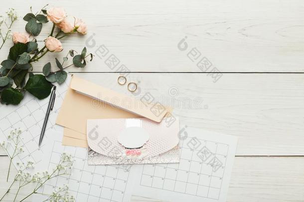 婚礼招待卡和信封向白色的木制的表,向