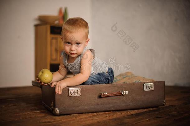 小的男孩一次采用指已提到的人手提箱和hold采用g一苹果