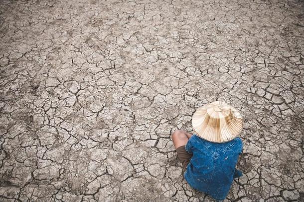 人向地面有裂缝的干的干燥的由于向干旱.