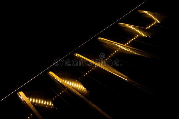部分关于对角线被照明的在旁边金色的楼梯向黑的后座