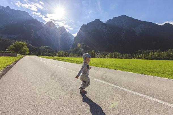 小的男孩跑步向大街被环绕着的在旁边风景和莫泰