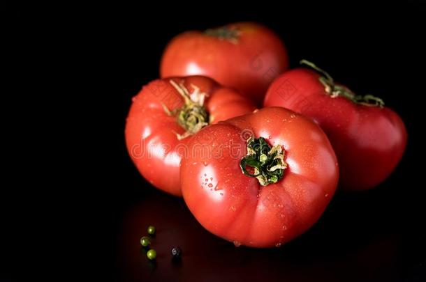 新鲜的美丽的红色的番茄和红辣椒和绿色的胡椒向黑的