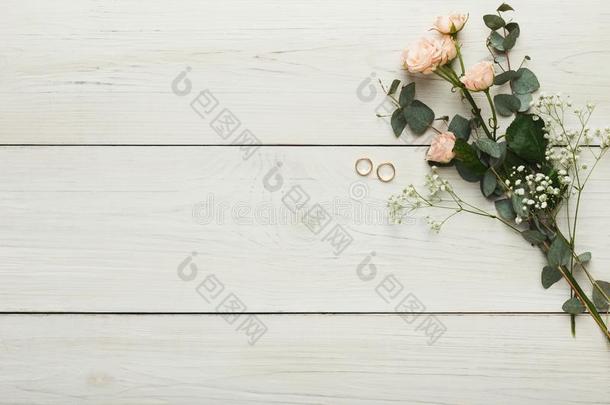 玫瑰和金色的戒指向白色的木材,婚礼背景
