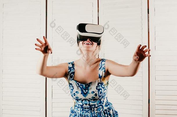 一白肤金发碧眼女人女人使人疲乏的VirtualReality虚拟现实眼镜,弄尖她手采用指已提到的人天空