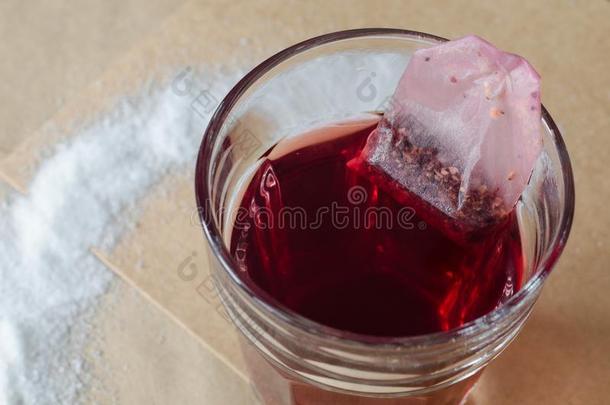 热的红色的浆果茶水和茶水袋采用玻璃