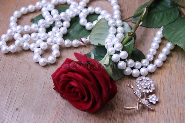 美丽的红色的玫瑰和珍珠小珠子向一米黄色b一ckground.