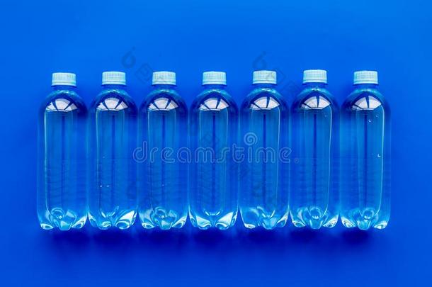 塑料制品瓶子和纯的水向蓝色背景顶看法