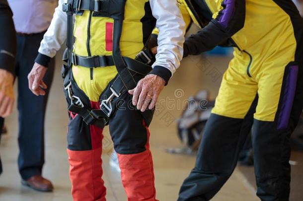做空中造型动作的跳伞运动员指导者助手学徒向关系安全腰带向他的