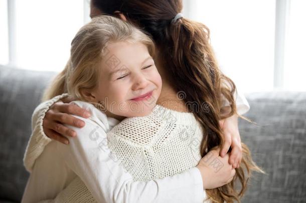 漂亮的小的女儿热烈地拥抱母亲,小孩爱为妈妈观念