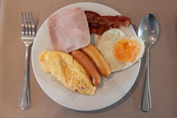 美国人早餐和火腿,腊肠,煎蛋饼,喝醉了的鸡蛋心