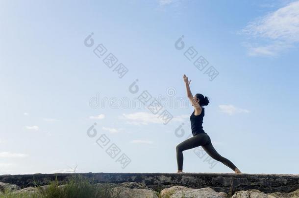 年幼的女人开业的瑜伽在下面蓝色天