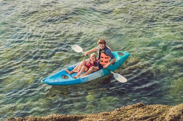 父亲和儿子皮艇运动在热带的洋.