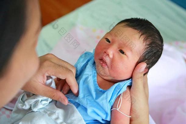 新生的婴儿向母亲手和敞开的眼睛