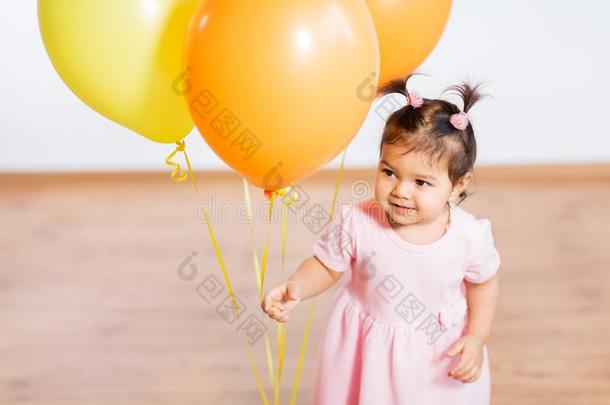 幸福的婴儿女孩和气球向生日社交聚会