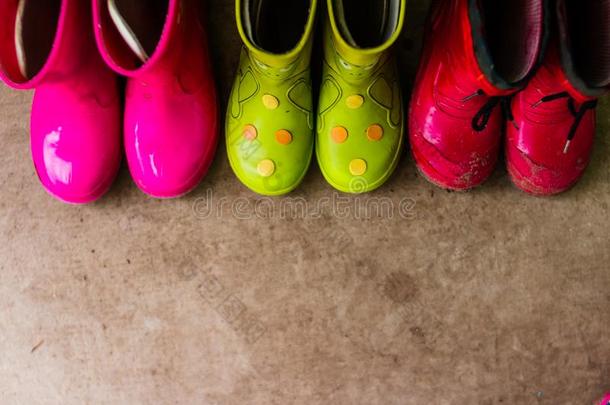 小孩明亮的粉红色的,红色的,绿色的橡胶擦靴人,园艺,擦靴人.下雨的