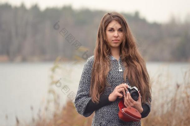 女孩摄影师和一老的照相机向指已提到的人湖