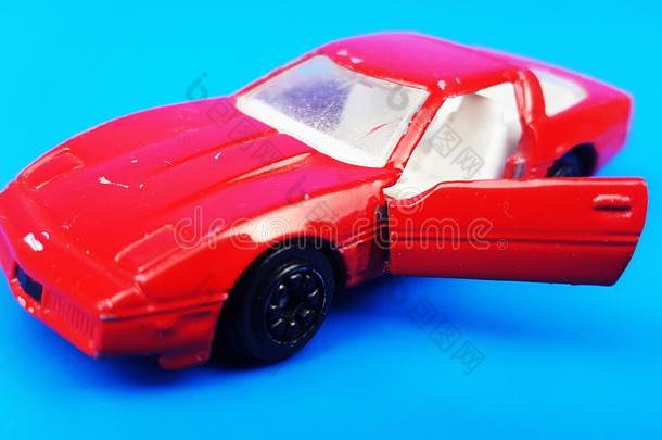 红色的汽车向蓝色背景和敞开的门.玩具汽车模型