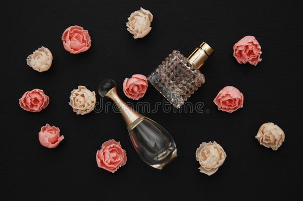 瓶子香水和伪造玫瑰向黑暗的黑的背景和复制品
