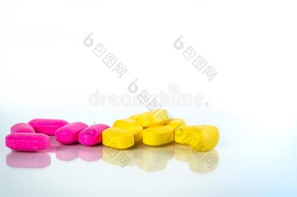 黄色的和粉红色的椭圆形的碑药丸和阴影向白色的后台