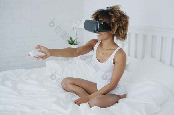 <strong>微笑</strong>的女人采用VirtualReality<strong>虚拟现实</strong>眼镜向床