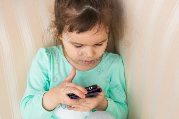 漂亮的小的女孩使用现代的智能手机