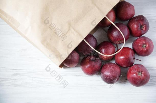 纸袋关于红色的苹果向光木制的背景.英语字母表的第12个字母
