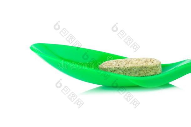 绿色的勺塑料制品和增补的大蒜隔离的向白色的