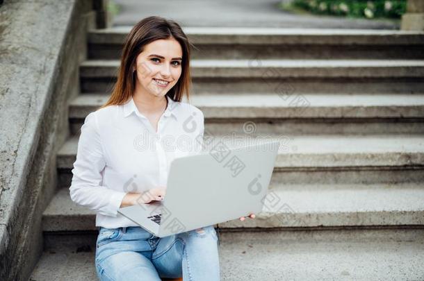 微笑的学生女孩一次向楼梯工作的和便携式电脑,进入预备学校