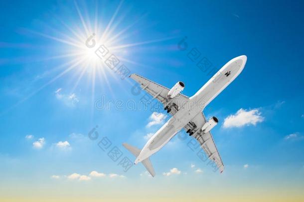 白色的飞机苍蝇采用一蓝色天和一明亮的太阳.